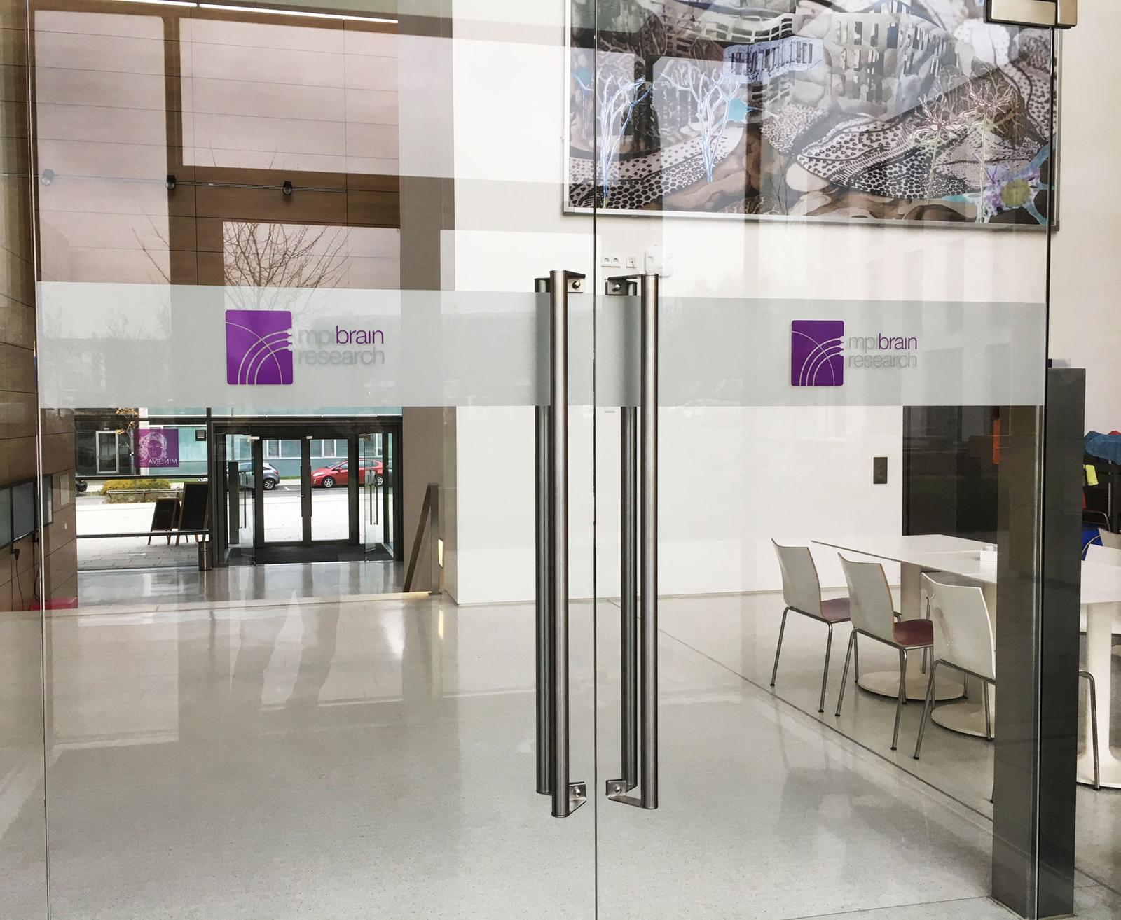 Eingangstür mit Gegenlaufschutz und Logobeschriftung einfache Sichtfolien und Glasdekor von anplakt